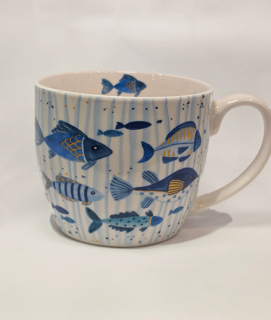 Tazza mug in ceramica bianca firmata Efya, impreziosita da una decorazione artistica a tema marino con pesciolini dipinti in varie sfumature di blu, azzurro e dettagli gialli. La superficie esterna presenta uno sfondo a delicate righe verticali azzurre con piccoli pois, mentre un ulteriore pesce decorativo è visibile sul bordo interno, rendendola un'idea regalo ideale o un perfetto complemento per la colazione estiva.