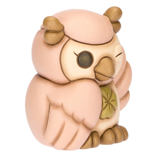 La statuetta Gufo Rosa Quadrifoglio THUN è un soprammobile in ceramica decorata a mano che ritrae un dolce gufetto dalle ali rosa mentre fa l'occhiolino e stringe un quadrifoglio portafortuna. Questa creazione artigianale dai colori pastello è un complemento d'arredo ideale per decorare con tenerezza ogni ambiente o come preziosa idea regalo da collezione.