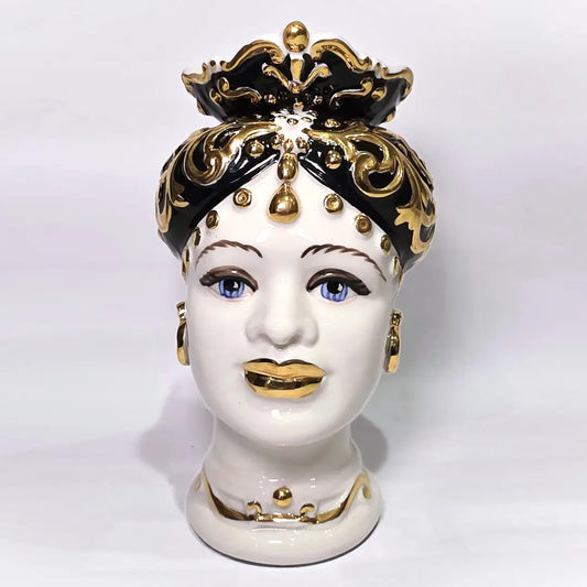 Coppia di Teste di Moro in ceramica artigianale bianca lucida con turbanti neri riccamente decorati da fregi e dettagli in oro zecchino. Queste sculture ornamentali raffiguranti un uomo con baffi e una donna con labbra dorate sono complementi d'arredo di lusso che reinterpretano la tradizione siciliana in chiave moderna ed elegante.