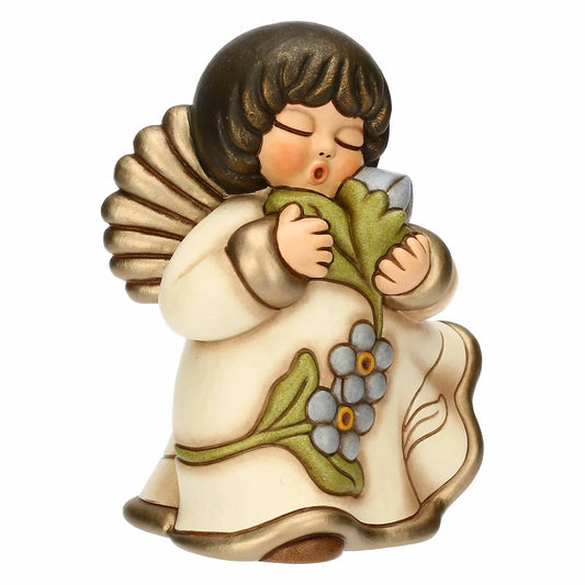 Statuina in ceramica Thun dell'Angelo dei Nonni Anna, collezione 2025. L'angelo è raffigurato con gli occhi chiusi, ali dorate e capelli castani. Indossa una veste color crema con bordi dorati e decorazioni floreali azzurre sulla parte inferiore. L'angelo tiene tra le mani un mazzo di fiori azzurri con foglie verdi, portandoli vicino al viso. Design classico Thun con finitura lucida e forme arrotondate.