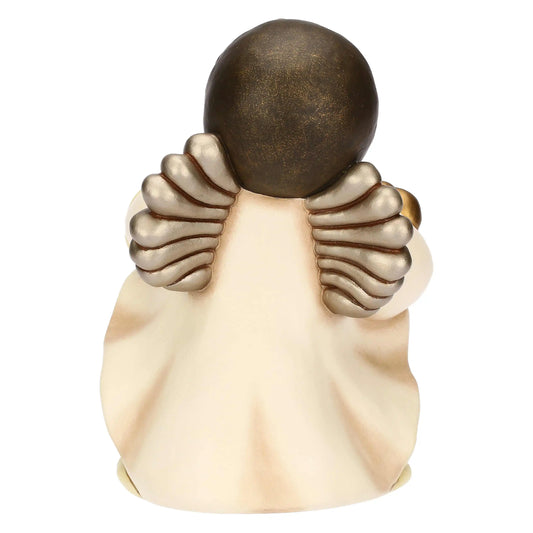 Fotografia del retro di una statuina in ceramica raffigurante un angelo. In primo piano risaltano le due ali simmetriche, corte e arrotondate, caratterizzate da piume stilizzate con una finitura metallizzata color argento bronzato. La testa, vista di nuca, presenta una capigliatura castano scuro dalla texture liscia e uniforme. La veste color crema cade ampia verso la base, formando morbide pieghe verticali sottolineate da sfumature più scure che donano tridimensionalità alla figura.