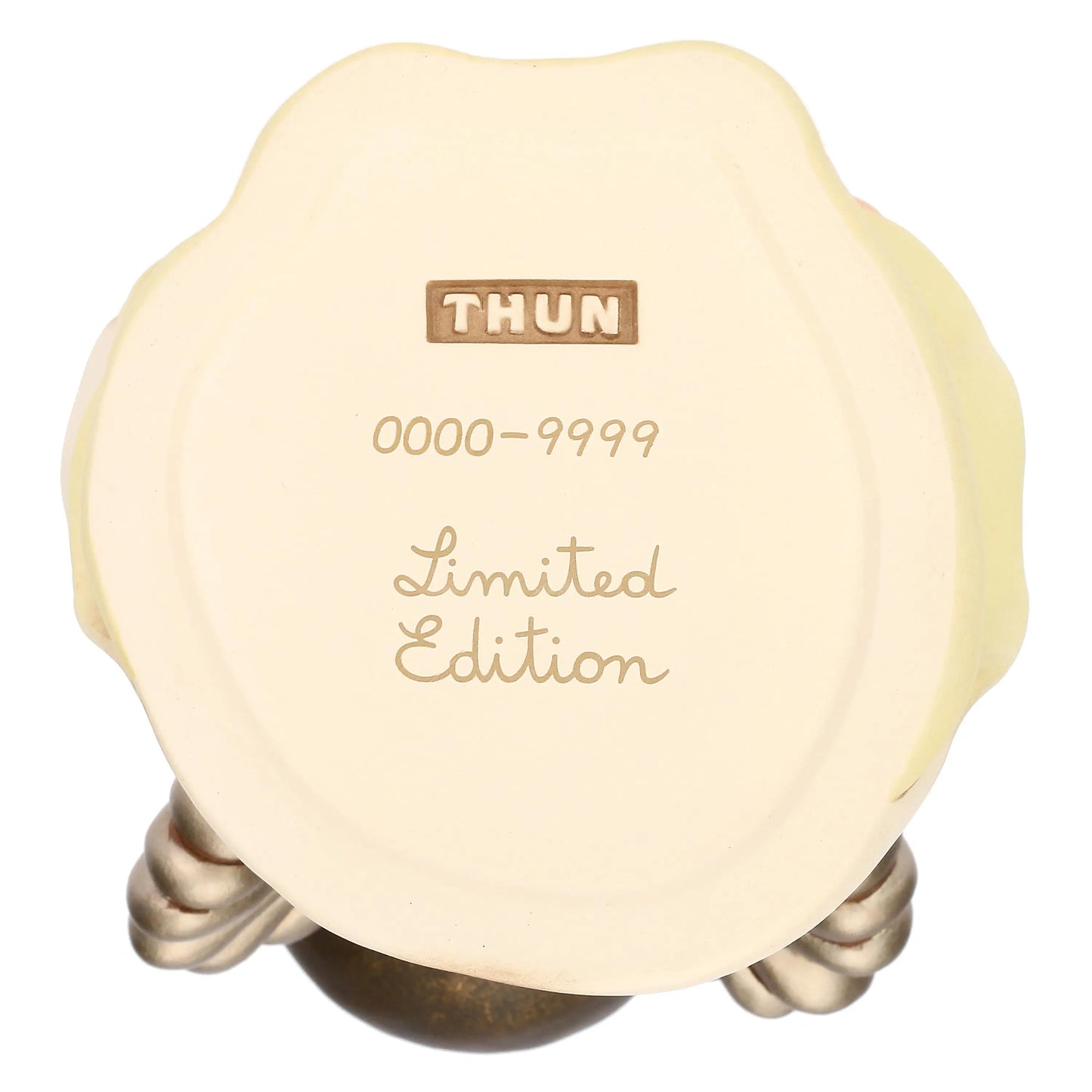 Fotografia in primo piano della base circolare e piatta di una statuina in ceramica color crema, vista dal basso su uno sfondo bianco. Al centro della base sono impressi tre elementi distintivi disposti verticalmente: in alto, il logo rettangolare "THUN" racchiuso in un piccolo riquadro; al centro, la numerazione "0000-9999" scritta in caratteri sottili; in basso, la dicitura "Limited Edition" realizzata in un carattere corsivo elegante.