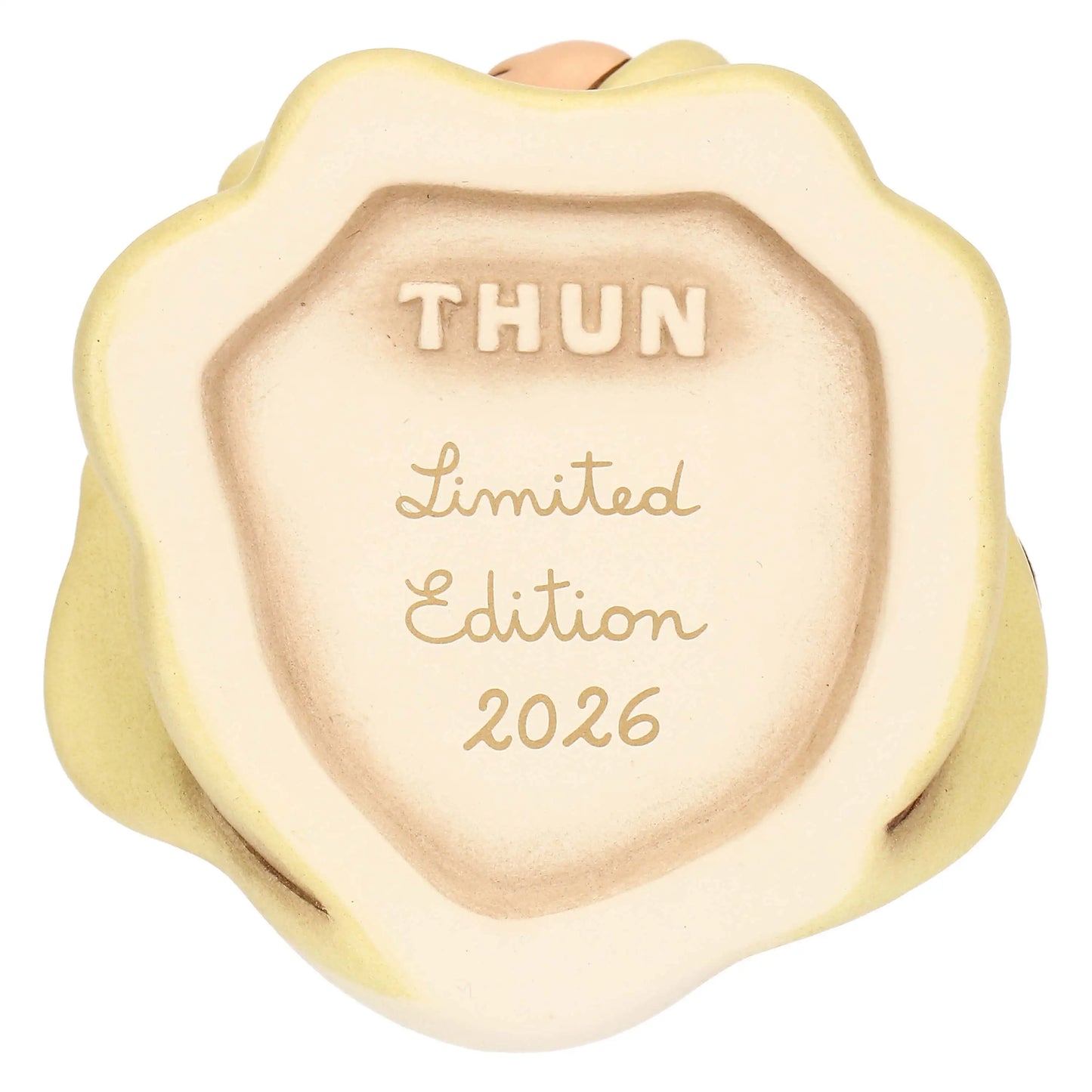 Inquadratura ravvicinata della base concava della statuina in ceramica, che funge da marchio di autenticità. La superficie è di colore avorio opaco e presenta delle scritte incise in rilievo color sabbia. Nella parte superiore è presente il logo "THUN" in stampatello maiuscolo. Al centro e nella parte inferiore si legge la dicitura "Limited Edition 2026" scritta in un elegante carattere corsivo. Il bordo esterno della base riprende la forma ondulata e il colore giallo sfumato della veste dell'angelo.
