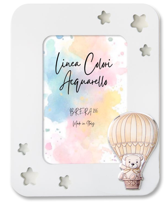 Portafoto da tavolo per bambini con cornice in legno bianco. L'angolo in basso a destra è decorato con un'applicazione smaltata in rilievo che raffigura un dolce orsetto seduto nel cestino di una mongolfiera a strisce beige e panna. All'interno è presente l'inserto "Linea Colori Acquarello - Brera 216 - Made in Italy" su sfondo sfumato pastello.
