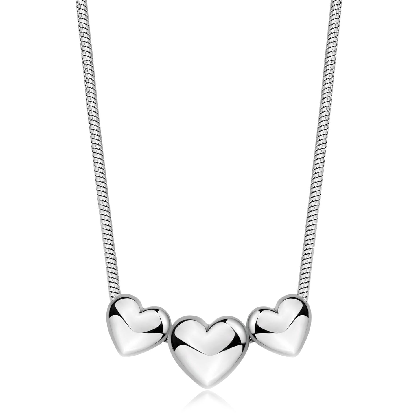 Collana in acciaio lucido con maglia a serpente e tre pendenti a forma di cuore bombato scorrevoli. I cuori specchiati degradano leggermente in dimensione, con il più grande posto al centro.