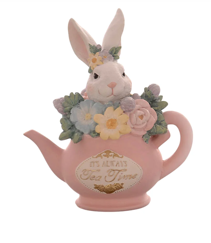 Statuina decorativa in resina che raffigura un coniglietto bianco che sbuca da una teiera rosa pastello colma di fiori (margherite gialle e azzurre, rose rosa). Il coniglio ha una piccola ghirlanda di fiori sulla testa. Sulla parte frontale della teiera è presente una placca bianca con bordi dorati e la scritta "It's always Tea Time". Design in stile vintage e fiabesco.