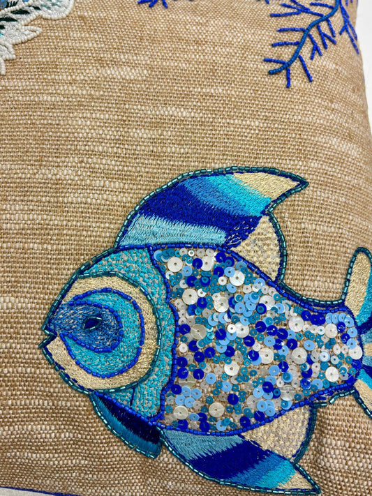 Dettaglio del Cuscino Blanc Mariclo' linea Maldive in lino naturale color beige. Stampa marina con pesci ricamati blu. Complemento d'arredo per case estive.