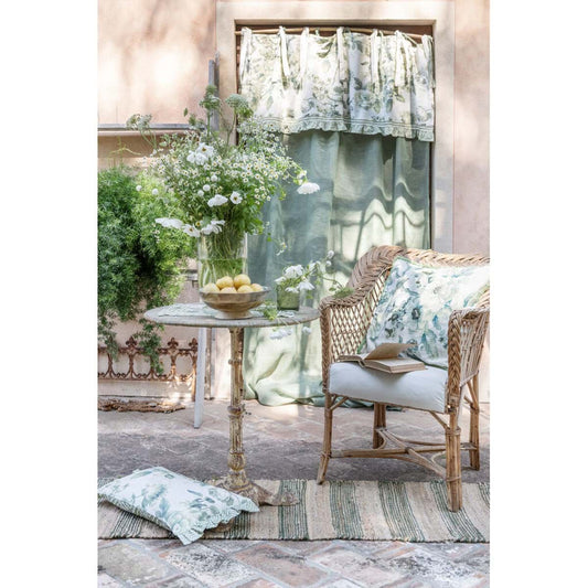 Ambientazione del cuscino Blanc Mariclo' linea Erborista in stile botanico vintage. Stampa con erbe officinali, fiori di campo e farfalle su fondo neutro. Arredo tavola elegante per un look naturale e country.