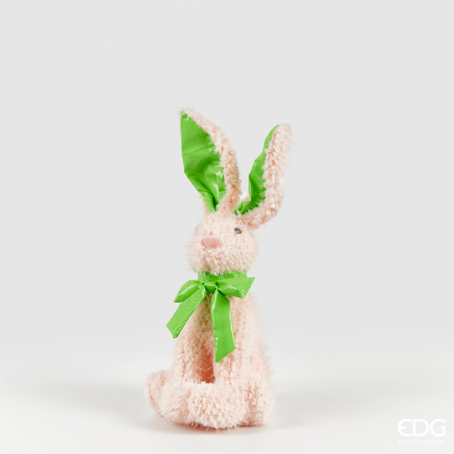 Peluche coniglietto pasquale EDG Enzo de Gasperi in morbido tessuto rosa cipria. Presenta lunghe orecchie e fiocco al collo in materiale lucido verde mela. Decorazione per Pasqua 2026 dal design tenero.