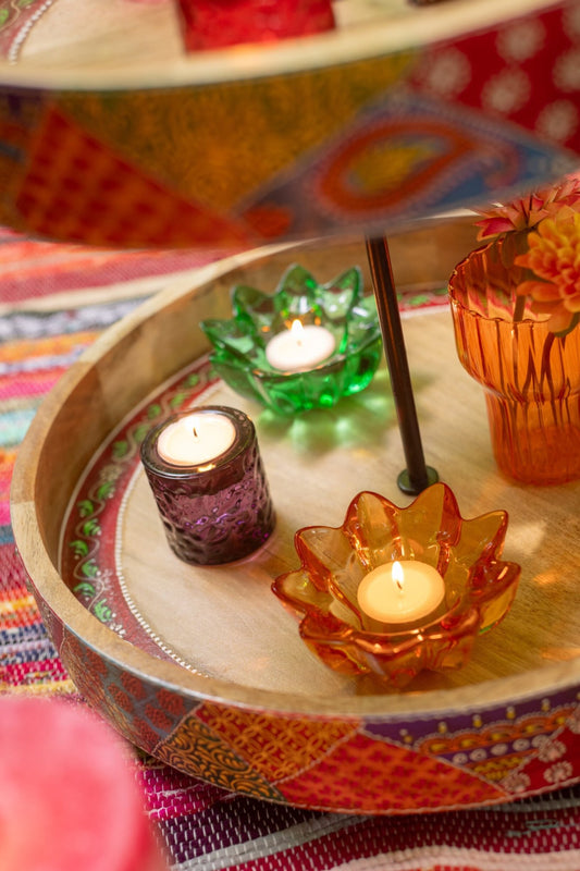 Portacandele a forma di fiore in vetro colorato assortiti firmati Jolipa, caratterizzati da petali sagomati e sfaccettati che creano eleganti riflessi di luce con le candele tea light. Disponibili nelle vivaci varianti trasparente rosa, ambra e verde, questi piccoli candelabri decorativi di design sono perfetti per abbellire la tavola, creare atmosfera negli interni o come colorata idea regalo home decor.