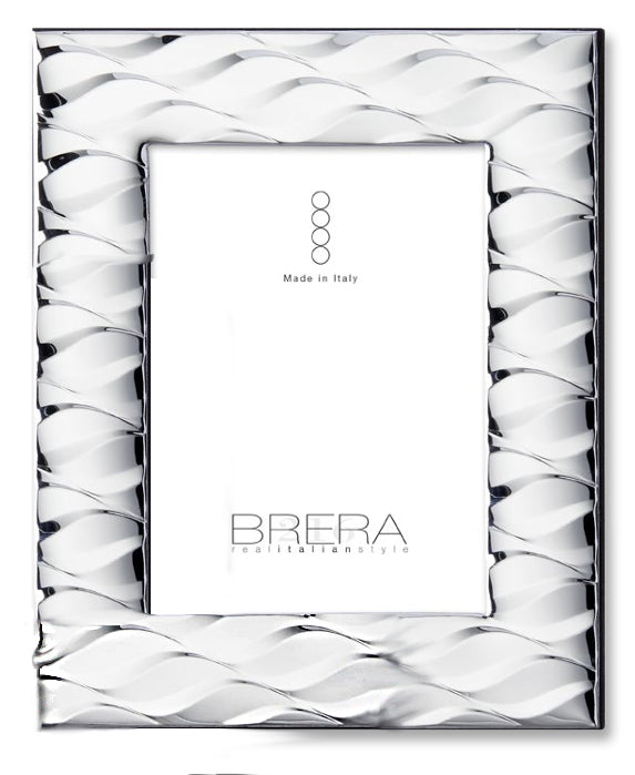 Portafoto rettangolare da tavolo in argento bilaminato con lavorazione a "cresta". La cornice è caratterizzata da un motivo a onde sbalzate in rilievo che creano un effetto specchiato e tridimensionale su tutta la superficie. L'inserto centrale riporta il logo "BRERA real italian style" e la dicitura "Made in Italy".