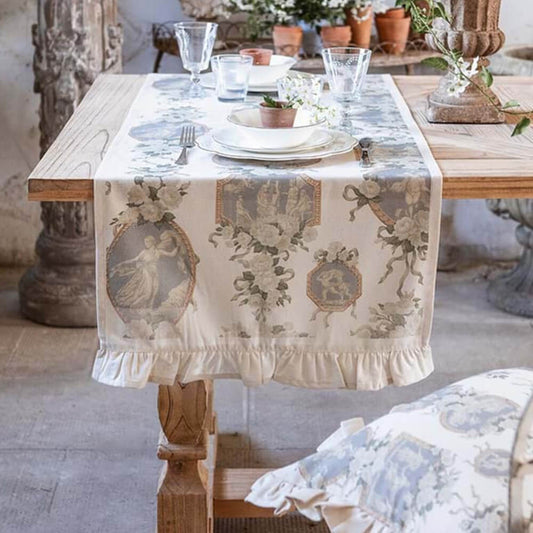 Ambientazione del runner con gala Blanc Mariclo' linea Blooming Poetry in stile shabby chic. Fantasia con rose bianche sfumate e fogliame verde e quadri classici con cornici dorate su fondo bianco, rifinito con romantico volant (gala) coordinato.