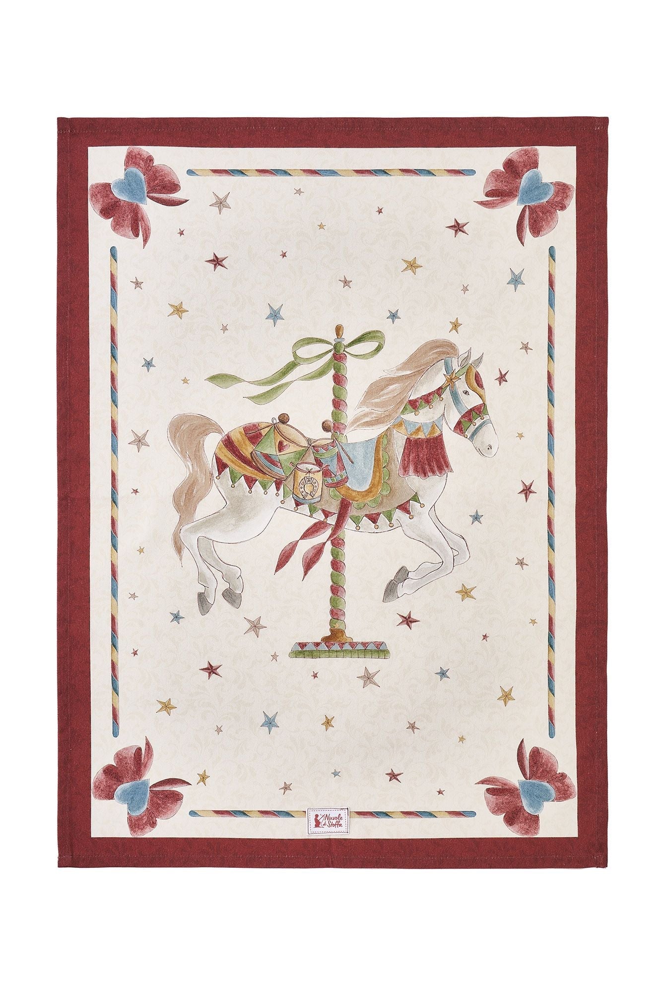 Strofinaccio natalizio Nuvole di Stoffa "La Giostra di Amelie" (Modello B). Al centro, un cavallo da giostra al galoppo riccamente decorato su fondo panna stellato. Cornice rossa con fiocchi azzurri e bordi a bastoncino di zucchero.