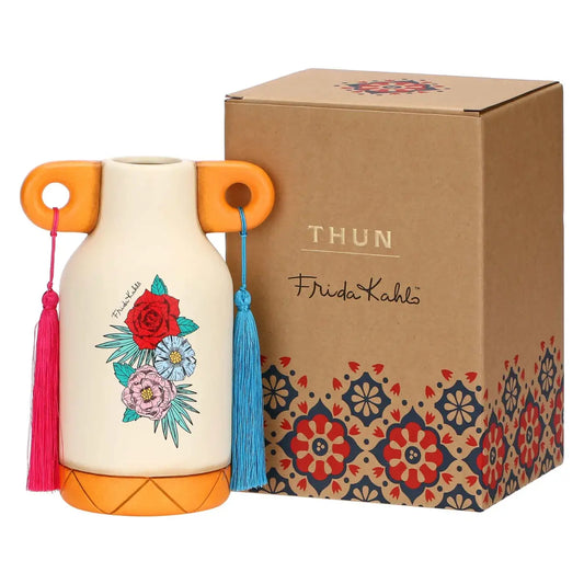 Questo raffinato vaso in ceramica della collezione THUN x Frida Kahlo presenta un design unico ispirato all'iconica artista, con decorazioni floreali vivaci e un cuore sacro centrale. La struttura color crema è arricchita da dettagli modellati a mano che includono farfalle colorate e una corona di fiori tipica dello stile Frida Kahlo. Perfetto come complemento d'arredo artistico, questo vaso THUN medio unisce l'estetica messicana alla dolcezza inconfondibile della ceramica decorata.