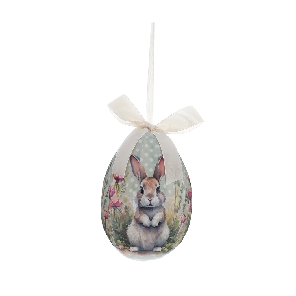 Decorazione su fondo verde menta a pois bianchi, raffigurante un coniglio circondato da fiori rosa e gialli, rifinito con fiocco color panna.