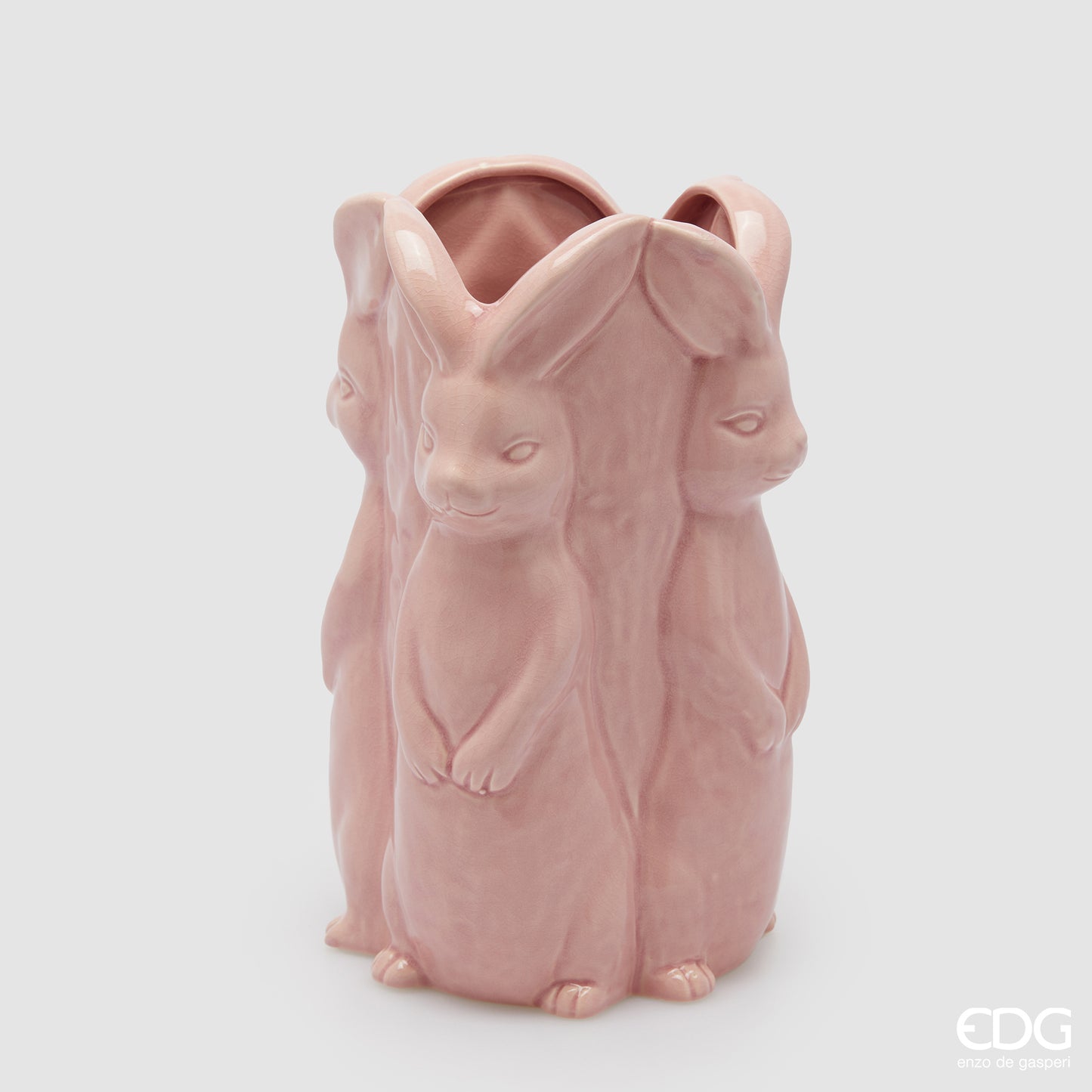 Vaso decorativo alto EDG Enzo De Gasperi linea Easter in ceramica rosa pastello. Design scultoreo composto da tre grandi conigli a figura intera che formano il corpo del vaso. Altezza 30 cm, stile elegante per la Pasqua.