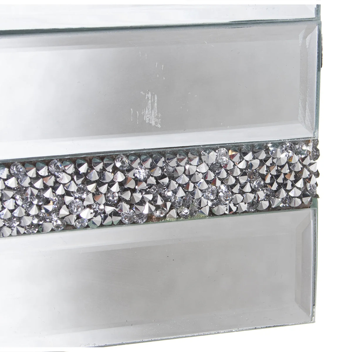 Portagioie rettangolare in vetro specchiato con coperchio liscio, decorato lungo la fascia centrale del corpo da una striscia di brillantini argentati incastonati. Scatola portagioie elegante firmata E-Camacho, ideale come oggetto d'arredo glamour o idea regalo raffinata.