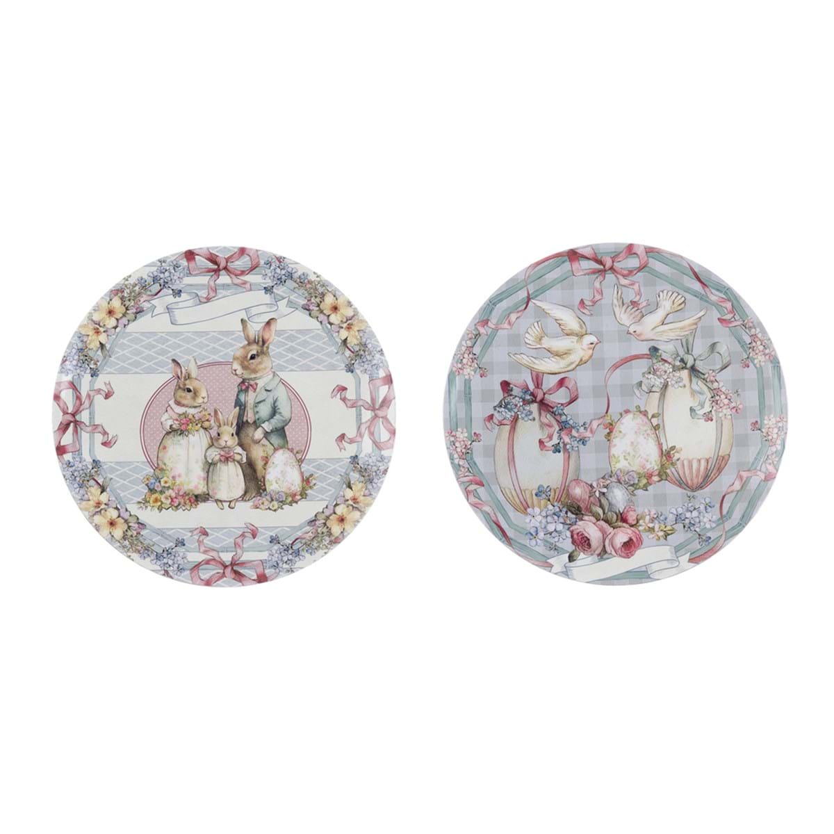 Sottopiatto pasquale della collezione "Joyeuses Paques" di Blanc Mariclo' con illustrazioni d'ispirazione vintage ideali per apparecchiare la tavola delle feste. L'immagine mostra due varianti rotonde assortite, una decorata con una famiglia di coniglietti e l'altra con colombe, uova e delicati motivi floreali sui toni del rosa e del celeste.