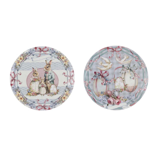 Sottopiatto pasquale della collezione "Joyeuses Paques" di Blanc Mariclo' con illustrazioni d'ispirazione vintage ideali per apparecchiare la tavola delle feste. L'immagine mostra due varianti rotonde assortite, una decorata con una famiglia di coniglietti e l'altra con colombe, uova e delicati motivi floreali sui toni del rosa e del celeste.