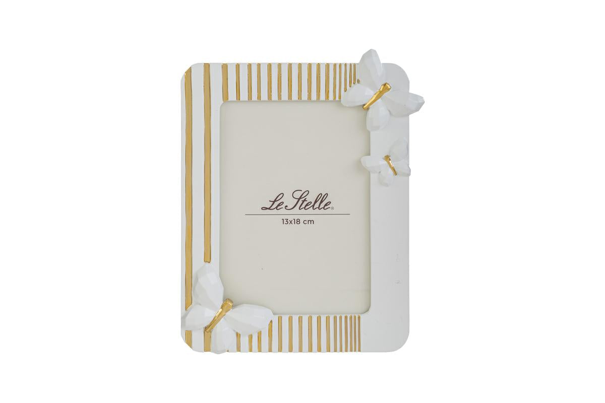 Questo raffinato portafoto in resina bianca firmato Le Stelle presenta un design moderno impreziosito da eleganti decorazioni a farfalla in rilievo e sottili linee dorate. La cornice rettangolare è perfetta per esporre fotografie di formato 13x18 cm, aggiungendo un tocco delicato e sofisticato a qualsiasi ambiente della casa. Grazie alla sua estetica curata, rappresenta un'idea regalo ideale per cerimonie o come complemento d'arredo per interni dallo stile contemporaneo.