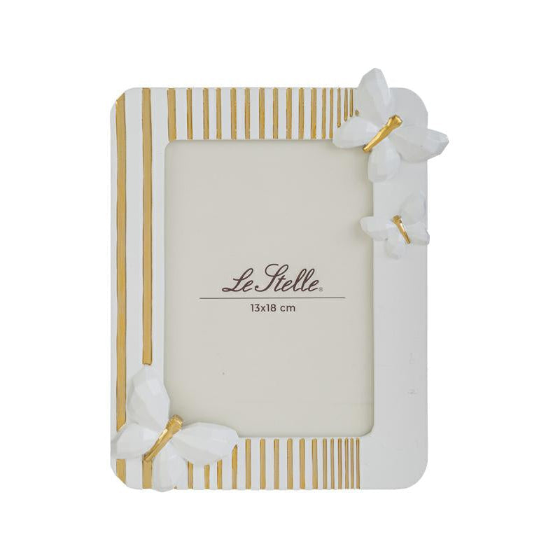 Questo raffinato portafoto in resina bianca firmato Le Stelle presenta un design moderno impreziosito da eleganti decorazioni a farfalla in rilievo e sottili linee dorate. La cornice rettangolare è perfetta per esporre fotografie di formato 13x18 cm, aggiungendo un tocco delicato e sofisticato a qualsiasi ambiente della casa. Grazie alla sua estetica curata, rappresenta un'idea regalo ideale per cerimonie o come complemento d'arredo per interni dallo stile contemporaneo.