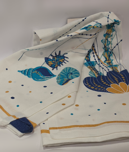 Strofinaccio da cucina in puro cotone del marchio Efya, caratterizzato da una vivace fantasia marina con pesci stilizzati e una medusa stampati nei toni del blu, azzurro e giallo ocra. Il canovaccio presenta un fondo bianco decorato da piccoli pois colorati sparsi, completato da una riga ocra sul bordo inferiore e da una pratica asola scura per appenderlo.