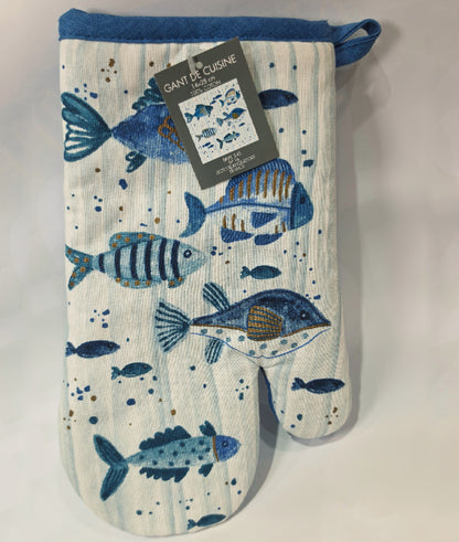 Guantone da cucina in cotone caratterizzato da una fantasia a tema marino con pesciolini stampati in varie tonalità di blu, azzurro e dettagli ocra. Il tessile presenta uno sfondo a righe verticali sfumate e un bordo superiore blu con asola per appenderlo, perfetto per proteggere le mani con stile durante la preparazione dei piatti.
