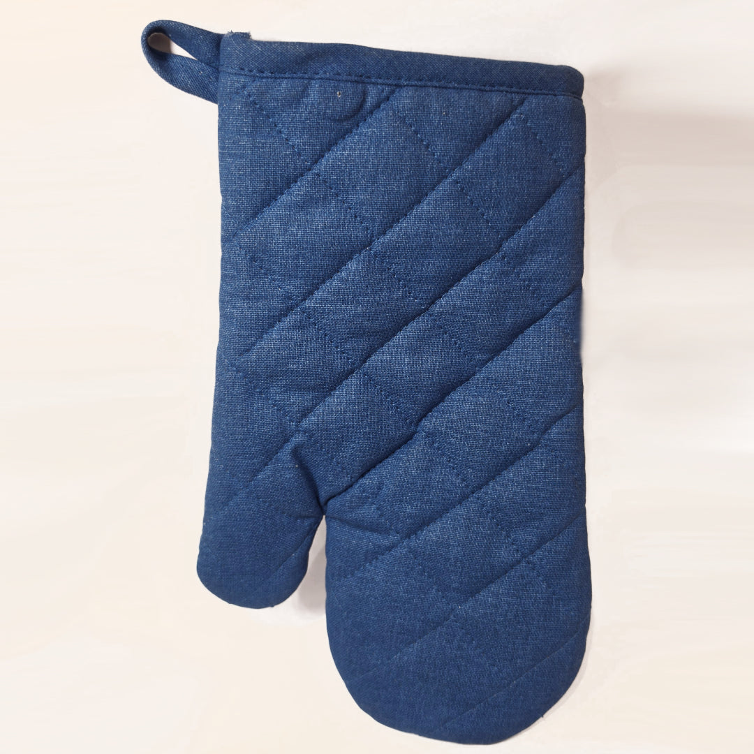 Guantone da cucina in cotone caratterizzato da una fantasia a tema marino con pesciolini stampati in varie tonalità di blu, azzurro e dettagli ocra. Il tessile presenta uno sfondo a righe verticali sfumate e un bordo superiore blu con asola per appenderlo, perfetto per proteggere le mani con stile durante la preparazione dei piatti.
