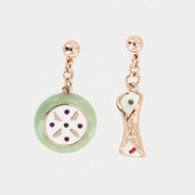 Orecchini pendenti asimmetrici BySimon della collezione Etna in oro rosa, con charm smaltati a forma di cassata siciliana e cannolo con dettagli rossi e verdi.
