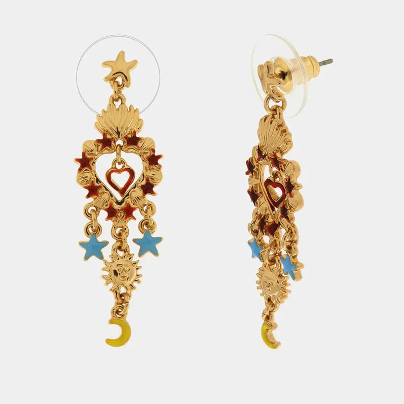 Orecchini pendenti BySimon della collezione Sacro con Cuore Sacro dorato traforato, stelle smaltate azzurre e rosse, e charm a forma di sole e luna gialla.