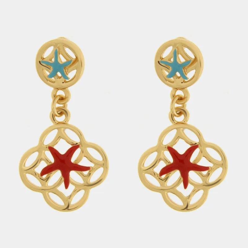 Questi orecchini pendenti dorati della collezione Fiori di Lava si distinguono per il doppio motivo marino con stelle marine smaltate in azzurro sul lobo e in rosso sul pendente principale. La struttura a maiolica traforata in metallo lucido incornicia delicatamente la stella marina centrale, creando un contrasto cromatico vivace e ricercato. Ideali per un outfit estivo, questi orecchini con stelle marine rosse e azzurre rappresentano perfettamente lo stile mediterraneo artigianale di bysimon.