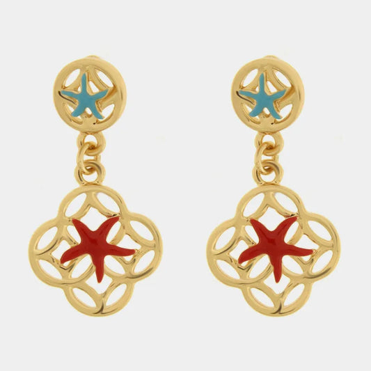 Questi orecchini pendenti dorati della collezione Fiori di Lava si distinguono per il doppio motivo marino con stelle marine smaltate in azzurro sul lobo e in rosso sul pendente principale. La struttura a maiolica traforata in metallo lucido incornicia delicatamente la stella marina centrale, creando un contrasto cromatico vivace e ricercato. Ideali per un outfit estivo, questi orecchini con stelle marine rosse e azzurre rappresentano perfettamente lo stile mediterraneo artigianale di bysimon.