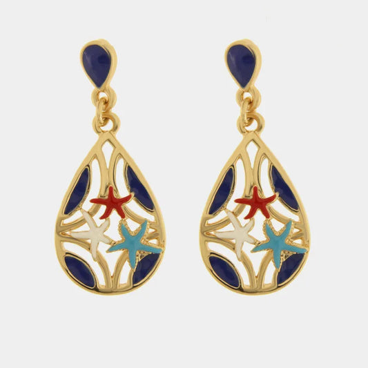 Questi orecchini a goccia della collezione Fiori di Lava presentano un raffinato design traforato in metallo dorato impreziosito da smalti colorati. Il pendente a forma di goccia racchiude tre piccole stelle marine nei toni del rosso, turchese e bianco, completate da eleganti dettagli blu scuro. Caratterizzati da una monachella a lobo con pietra blu, questi orecchini colorati a tema marino offrono uno stile estivo e sofisticato ideale per ogni occasione.