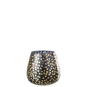 Portacandele decorativo in vetro nero semitrasparente caratterizzato da una raffinata trama geometrica a piccoli triangoli dorati che rivestono l'intera superficie bombata. Questo elegante bicchiere portacandela lascia trasparire una luce calda e soffusa, rendendolo un complemento d'arredo di design ideale per creare un'atmosfera accogliente in casa.