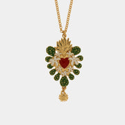 Collana BySimon della collezione Sacro con catena dorata a maglie circolari, caratterizzata da un grande pendente centrale a forma di Cuore Sacro smaltato rosso e charm laterali raffiguranti fichi d'india verdi.