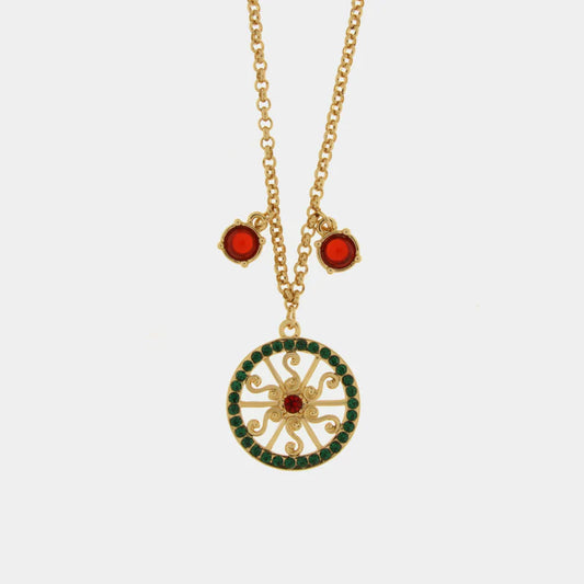 Collana dorata BySimon della collezione Taormina con pendente circolare a forma di ruota del carretto impreziosito da cristalli verdi e rossi, con due charms laterali a punto luce rosso.