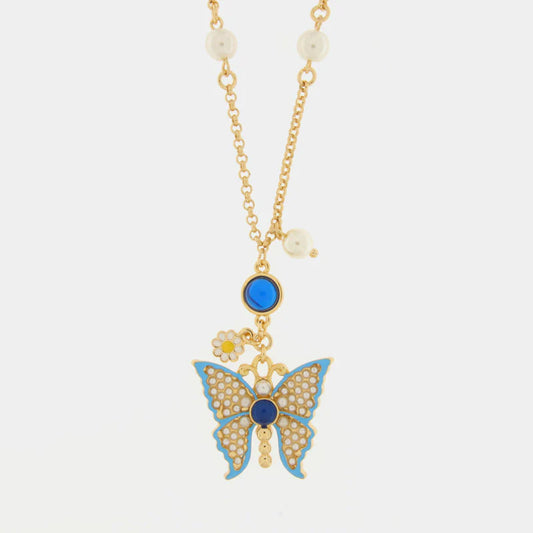 Collana BySimon della collezione Favignana con catena dorata arricchita da perle bianche, caratterizzata da un pendente centrale con farfalla turchese decorata da microperle e una piccola margherita smaltata laterale.