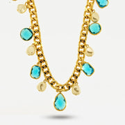 Collana a catena dorata con cristalli sfaccettati color celeste in forme variegate e perle barocche pendenti. Gioiello scenografico dal forte impatto visivo, ideale per occasioni speciali e come idea regalo.