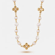 Collana in metallo dorato con perle bianche classiche, perle barocche irregolari e tre fiori a quattro petali con perla centrale. Gioiello elegante e variegato, ideale per occasioni speciali e come idea regalo.