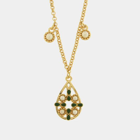 Collana in metallo con finitura dorata del marchio BySimon appartenente alla collezione Fiori di Lava caratterizzata da una catenina sottile a maglia rolo che sostiene un pendente a goccia traforato ispirato alle maioliche mediterranee. Il ciondolo principale presenta un decoro centrale a croce in smalto verde scuro circondato da quattro perle bianche incastonate in una cornice dorata lavorata a sbalzo. Lungo la catena sono presenti due ulteriori piccole perle bianche decorative