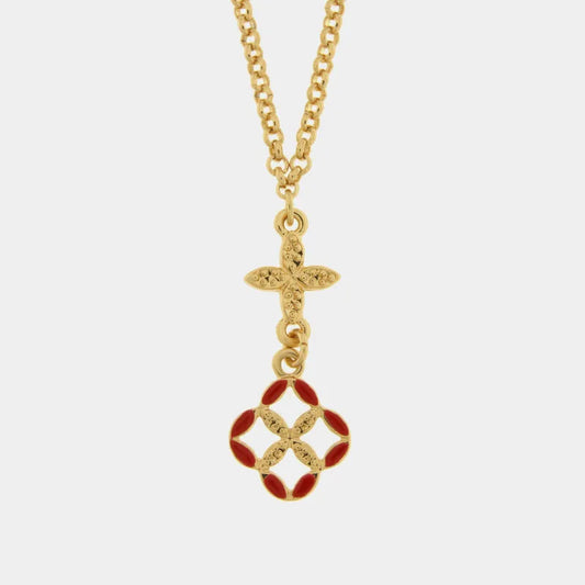 Collana con catena dorata e pendente Fiori di Lava su fondo bianco neutro. Il ciondolo è composto da un elemento dorato a croce filigranata e un ciondolo floreale stilizzato smaltato rosso e oro. L'accessorio appartiene alla collezione Maiolica Rossa di Fiori di Lava.