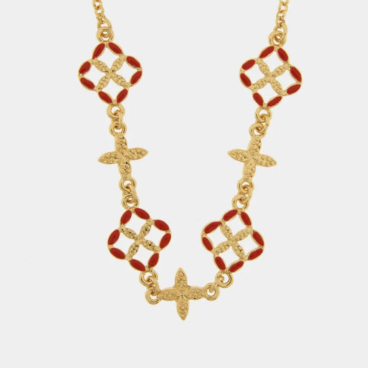 Questa elegante collana dorata della collezione Fiori di Lava firmata bysimon presenta un design raffinato con pendenti a forma di maioliche smaltate in un vivace rosso corallo. L'alternanza tra i motivi floreali traforati e i piccoli charms a croce in metallo dorato testurizzato rende questo gioiello un accessorio dallo stile mediterraneo unico e sofisticato. Perfetta per impreziosire ogni outfit, la collana bysimon con maioliche rosse celebra l'artigianato d'ispirazione siciliana 
