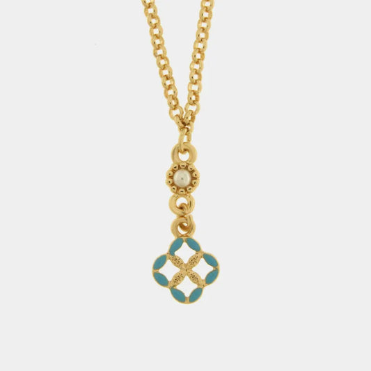 Collana in metallo con finitura dorata del marchio BySimon appartenente alla collezione Fiori di Lava caratterizzata da una sottile catenina a maglia rolo che sostiene un pendente centrale a forma di quadrifoglio traforato. Il ciondolo è ispirato alle tradizionali maioliche siciliane e presenta petali rifiniti in smalto azzurro brillante con una lavorazione dorata a rilievo nel cuore del decoro.