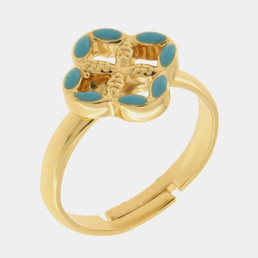 Anello regolabile in metallo con finitura dorata del marchio BySimon appartenente alla collezione Fiori di Lava caratterizzato da un castone centrale a forma di quadrifoglio stilizzato che richiama i decori della Maiolica . Il gioiello è impreziosito da smalto azzurro applicato sui petali esterni e presenta un motivo a rilievo finemente lavorato nella parte centrale della struttura superiore. La fascia dell'anello è lucida e aperta sul retro per permettere di adattare facilmente la misura al dito, rendendo