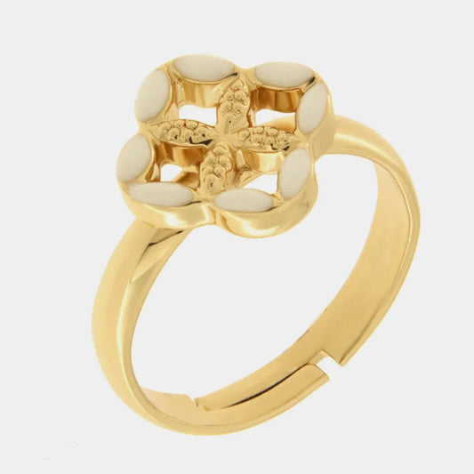 Anello regolabile in metallo con finitura dorata del marchio BySimon appartenente alla collezione Fiori di Lava caratterizzato da un castone centrale a forma di quadrifoglio stilizzato che richiama i decori della Maiolica. Il gioiello è impreziosito da smalto bianco applicato sui petali esterni e presenta un motivo a rilievo finemente lavorato nella parte centrale della struttura superiore. La fascia dell'anello è lucida e aperta sul retro per permettere di adattare facilmente la misura al dito, rendendo