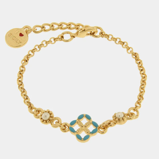 Bracciale in metallo con finitura dorata del marchio BySimon appartenente alla collezione Fiori di Lava caratterizzato da un design mediterraneo con maglia a catena rolo. Il gioiello presenta un elemento centrale a forma di quadrifoglio traforato ispirato alle maioliche siciliane, decorato con smalto azzurro sui petali e un motivo a rilievo dorato nel mezzo. Ai lati del decoro centrale sono incastonate due piccole perle bianche circondate da una lavorazione granulata. Completano il bracciale una chiusura a 