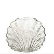 Vaso decorativo in vetro trasparente a forma di conchiglia della collezione "Oceano Azul" di Jolipa, caratterizzato da una superficie lavorata con scanalature verticali a rilievo che riflettono la luce. Questo originale complemento d'arredo di ispirazione marina è ideale per ospitare fiori freschi o come elegante centrotavola per impreziosire gli ambienti di casa.