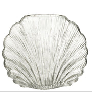 Vaso decorativo in vetro trasparente a forma di conchiglia della collezione "Oceano Azul" di Jolipa, caratterizzato da una superficie lavorata con scanalature verticali a rilievo che riflettono la luce. Questo originale complemento d'arredo di ispirazione marina è ideale per ospitare fiori freschi o come elegante centrotavola per impreziosire gli ambienti di casa.