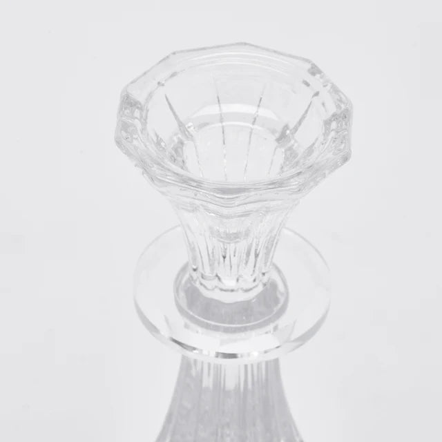 Candelabro in vetro trasparente modello Crystal firmato EDG Enzo de Gasperi, caratterizzato da un'elegante struttura classica con fusto sinuoso e scanalature verticali riflettenti. Questo raffinato portacandele di design presenta una base circolare lavorata, ideale come centrotavola decorativo per illuminare e impreziosire gli ambienti di casa.