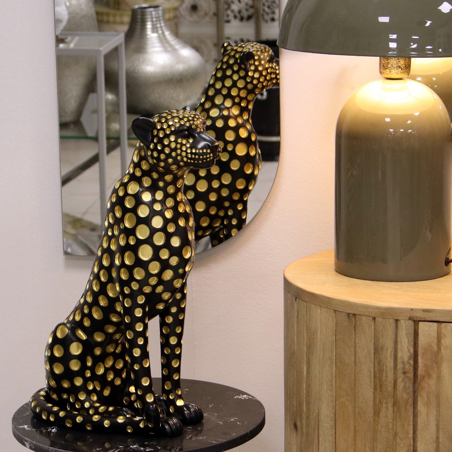 Figura in resina di leopardo nero e oro firmata e-camacho, raffigurante un ghepardo seduto di profilo con un design moderno ricoperto da pois dorati a rilievo. Questa statuina decorativa e scultura da collezione rappresenta un soprammobile di lusso ideale per l'arredamento d'interni elegante e di design.